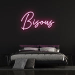 Bisous LED neon sign in bright pink color, installed in a bedroom, adding a playful and vibrant touch to the decor