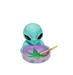 Ceramic alien round ashtray by Fashioncraft, featuring a unique green alien holding a purple ashtray with cannabis leaf design, ideal for smokers and collectors.