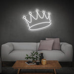 White crown LED neon sign on dark wall in a modern living room with contemporary decor.