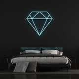 Light blue diamond-shaped LED neon sign on black wall in modern bedroom with bed and pillows.