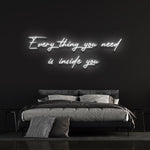 Everything you need is inside you neon sign in white, adding a sleek look to a stylish bedroom.