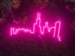 Bright pink Chicago skyline neon LED sign illuminated against a lush green background, ideal for vibrant decor.